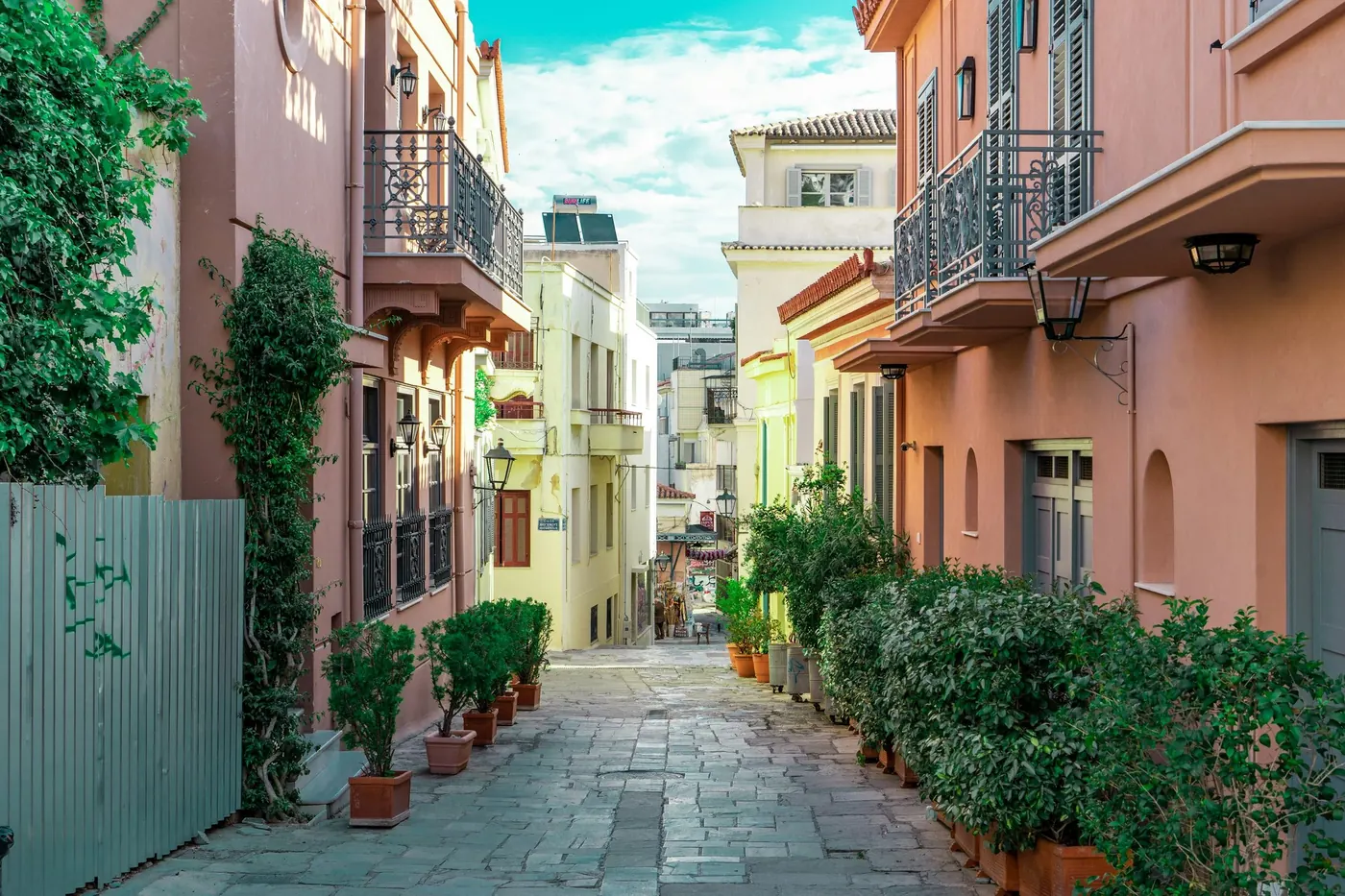 ممر مشاة مظلل بالأشجار بين مبانٍ ملونة في أثينا