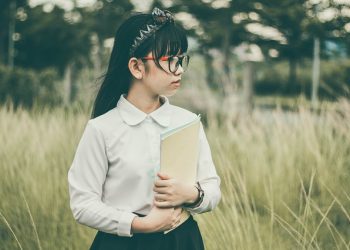 Young student posing with a textbook