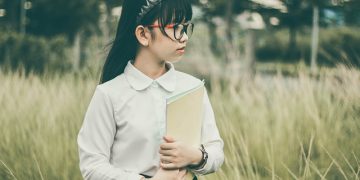 Young student posing with a textbook