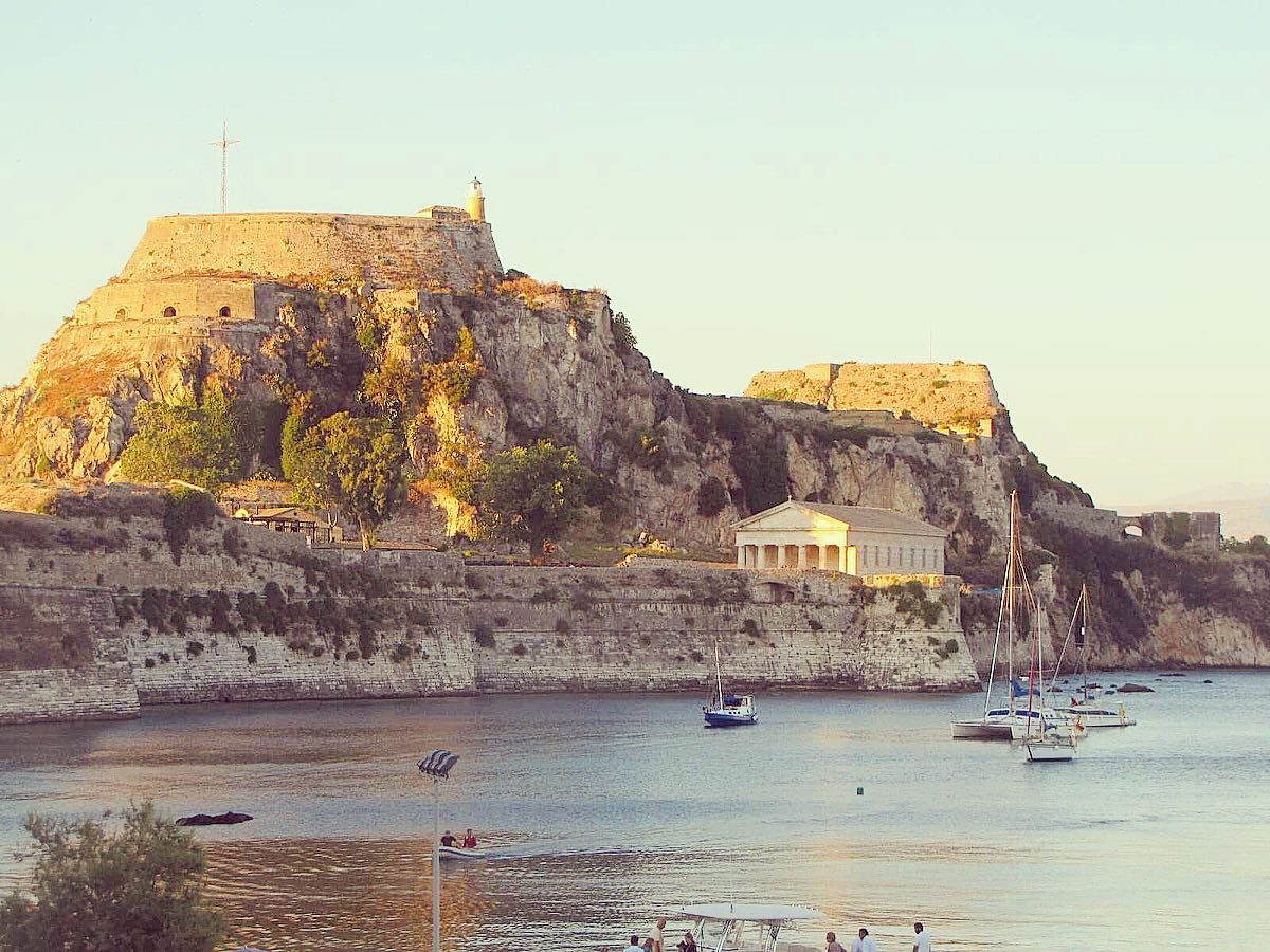 Corfu, Kerkira in the Ionian islands in Greece. View from a quiet beach, overlooked by a castle, the Old Fortress, and a temple.