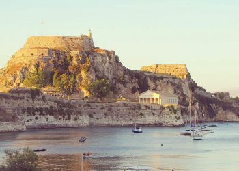 Corfu, Kerkira in the Ionian islands in Greece. View from a quiet beach, overlooked by a castle, the Old Fortress, and a temple.