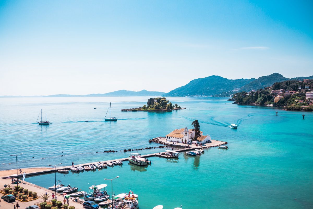 Landscape of Corfu during a very calm sunny day. The turquoise water begins from the small port nearby and spreads all the way back to the horizon, in neighbouring islands, encompassing Pontikonisi, a tiny island a stone's throw from Corfu.