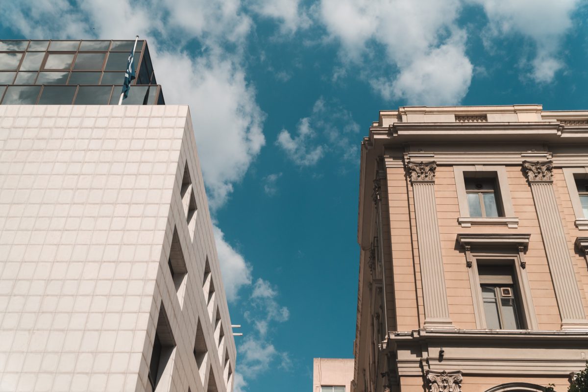 View from the street of two buildings in Athens, Greece, one of neoclassical architecture and the other of contemporary style